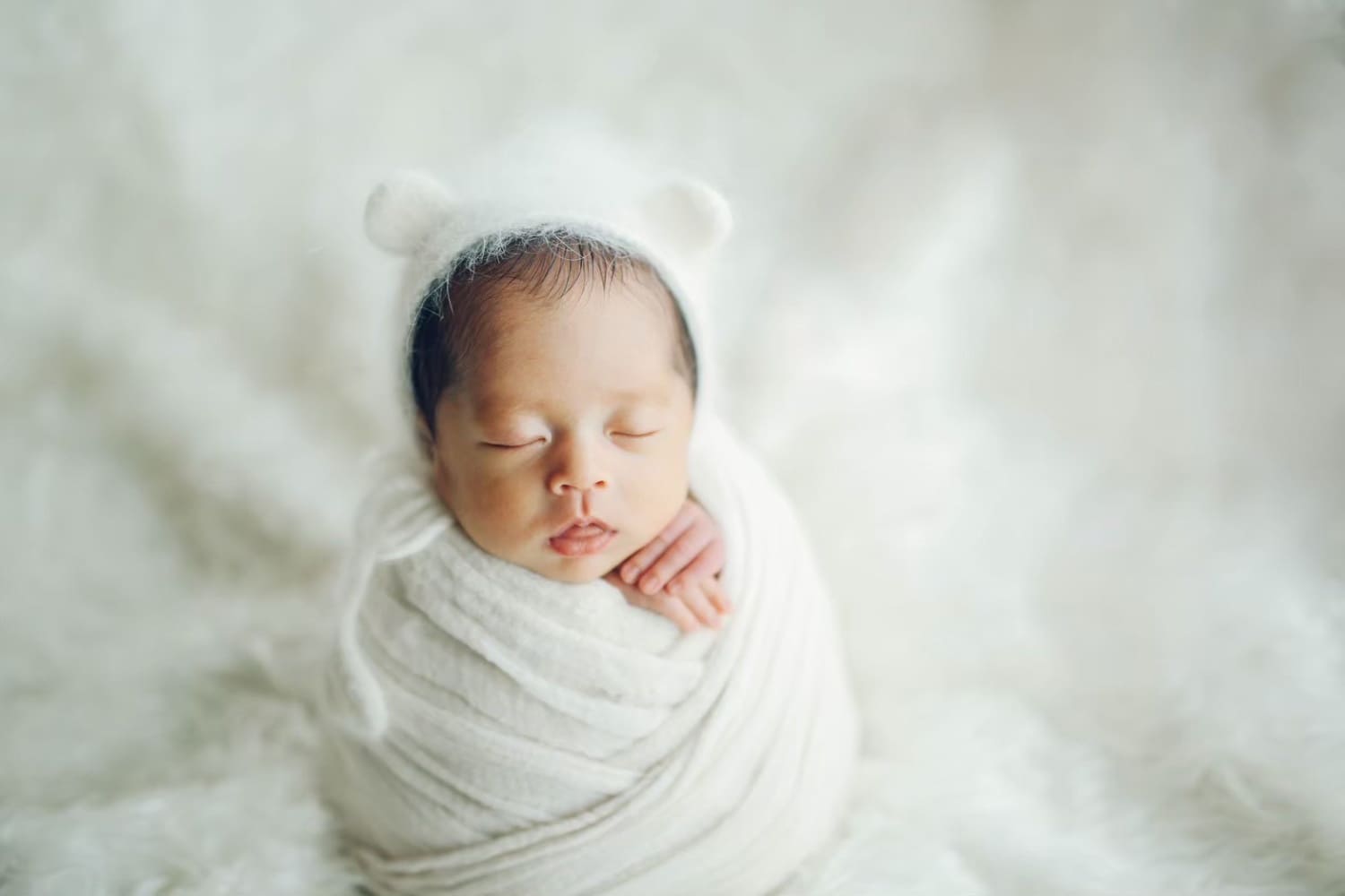 胎内姿勢のまんまる姿勢で眠る新生児のニューボーンフォト